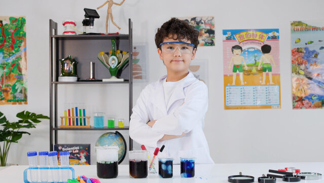 Young Asian Boy in Lab Coat Posing Proudly in Science Classroom