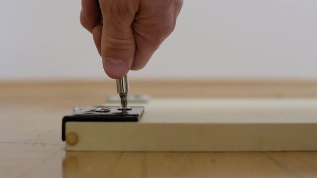 Routine evaluation of door rollers and hardware stability in apartment. Assessing functionality of wardrobe door rollers and screw tightness during regular maintenance