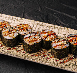 Unagi maki sushi rolls with sesame seeds and sauce © AntAlexStudio