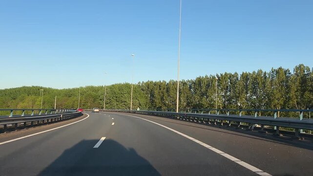 Amsterdam Netherlands highway, Curving highway through a wooded landscape in bright daylight