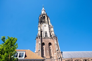 Fototapeta premium Nieuwe Kerk New Church Gothic tower above Delft city center under blue sky, Netherlands