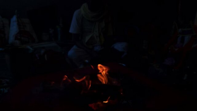 Sacred Hindu Havan Homam Yajna fire ritual being performed during a religious puja ceremony in India. The holy fire burns brightly in a traditional fire altar while devotees offer prayers