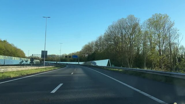 Amsterdam Netherlands highway, Curving highway with light traffic under clear blue sky
