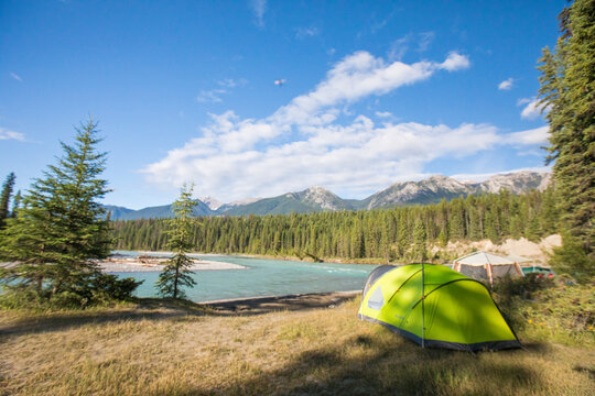 Scenic campsite by a river and mountains