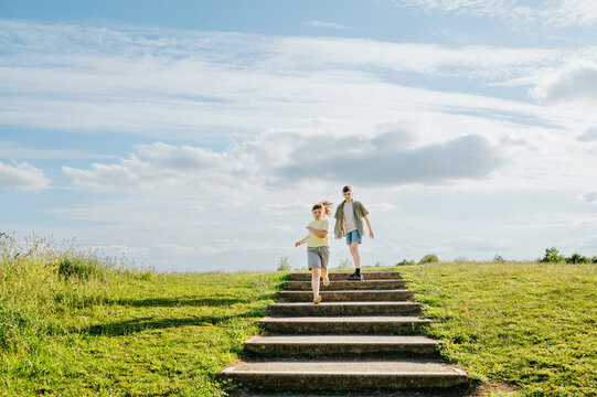 Brother and sister running down outdoor steps together