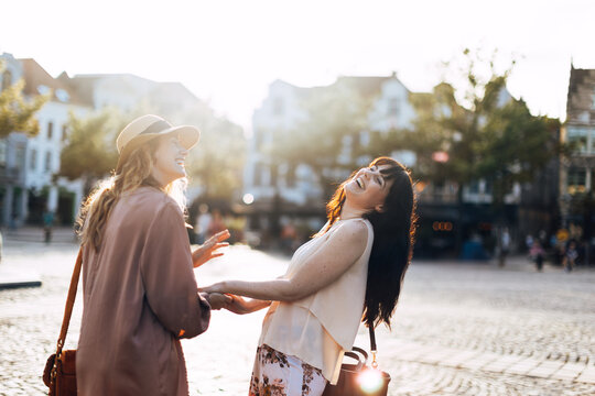 Happy young women enjoying city life laughing outdoors