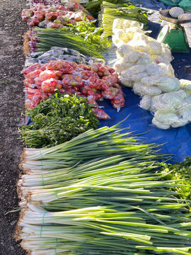 Fresh vegetables displayed at local outdoor market featuring spring onions, cabbage and produce for healthy eating