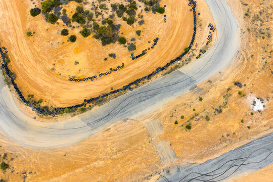 aerial view of kart track with tyres at edge of track with dirt and bitumen