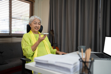 Fototapeta premium senior asian woman speaking on smart phone with chatbot AI, technology artificial intelligence on smartphone with assistant and consult of elder woman, female using voice on phone