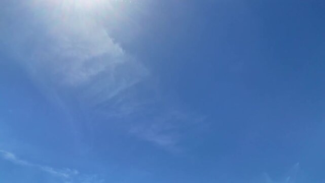 Cielo azzurro con sole brillante e leggere velature, in una scena luminosa e serena tipica delle giornate estive