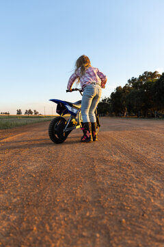 Young girl learning to ride a motorbike in a countryside