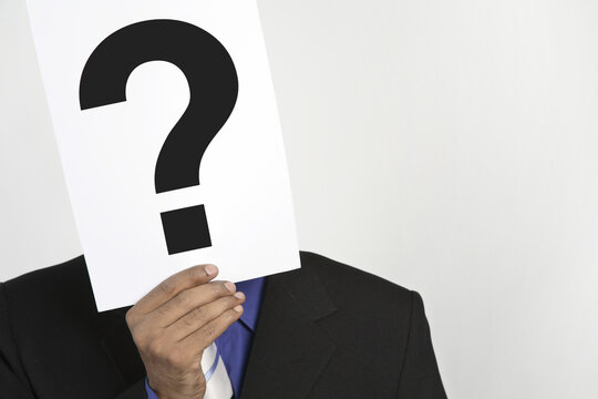 businessman holding question mark