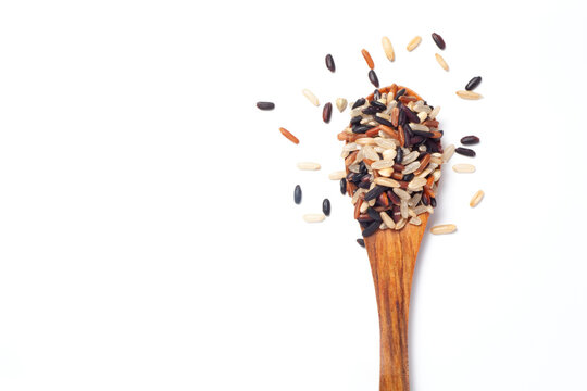 Seven different organic rice grains in a wooden spoon on white backgroiund, Healthy food concept