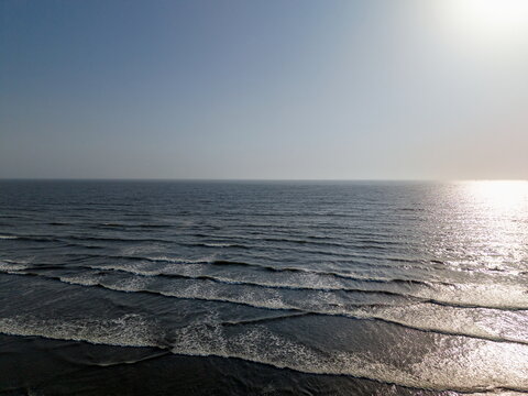 Aerial view of Sea-View Beach with gentle waves rolling onto the sandy shore under a clear sky in Karachi, Sindh, Pakistan.