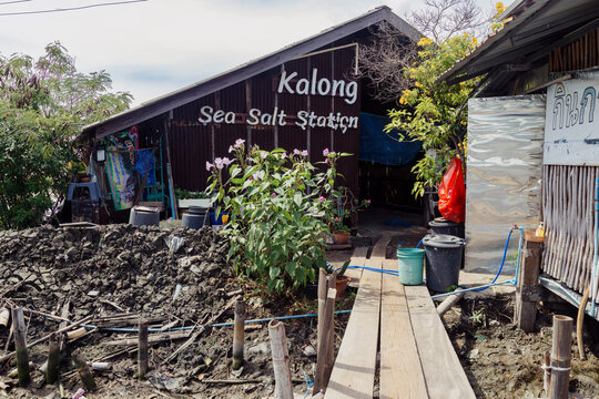 BANGKOK, THAILAND, 6 October 2025 &ndash; A rustic sign reads "Kalong Sea Salt Station" above a weathered building, a local salt production in a coastal area.