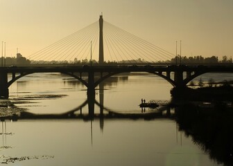 Fototapeta premium Guadiana river bridge reflecting during a golden sunset