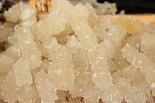 Crystallized rock sugar displayed in abundance at Siab bazaar in Samarkand. Close-up of translucent sugar crystals with sparkling texture, ideal for food or travel content.