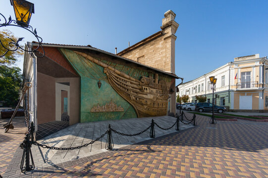 Unique fa&ccedil;ade of Alexander Green Literary Memorial Museum resembles ship emerging from wall. Neighboring buildings exemplify classical architectural style. Feodosia, Crimea &ndash; October 14, 2014