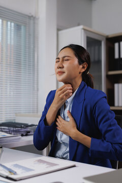 Stressed businesswoman suffering sore throat chest pain working office