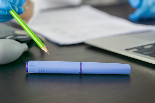 ozempic pen hand holding medical injection weight loss drug office desk background, doctor reviewing patient documents with diabetes medication, clinical treatment process