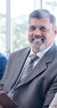 Face, business and man in waiting room with smile, recruitment and job interview for vacancy. Portrait, mature person and candidate with clipboard for hiring, human resources process and onboarding