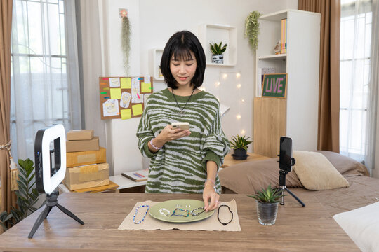 Young online seller Preparing for handmade jewelry live streaming in home studio