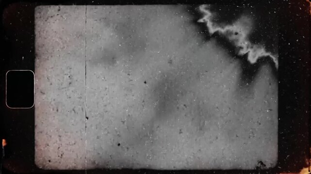 Old film strip showing abstract black and white smoky textures with visible sprocket holes