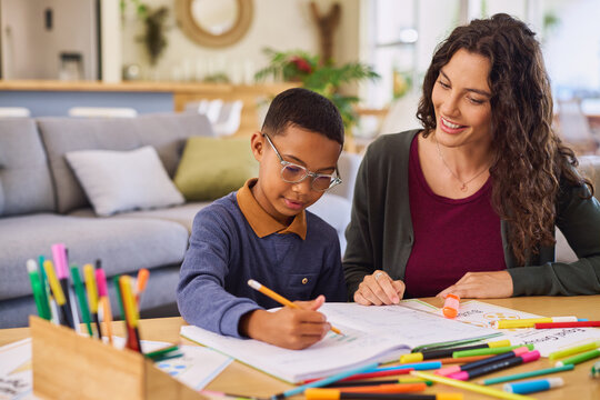 Mid adult woman helping son with homework at home
