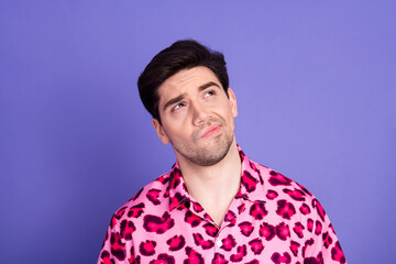Fototapeta premium Handsome young man wearing trendy pink leopard print shirt posing against a vibrant purple background