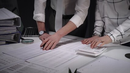 Business professionals analyzing financial documents, using magnifying glass for meticulous data review, focusing on audit, investigation, fraud detection, and regulatory compliance © Hanna