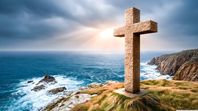 Stone cross on a grassy cliff above a deep blue ocean