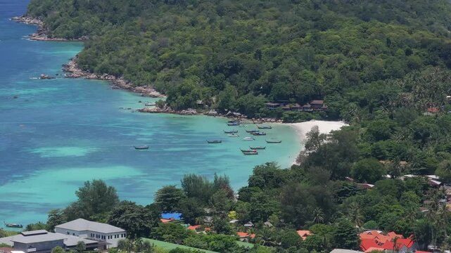 Aerial drone view of Koh Lipe island, Satun, Thailand. Turquoise sea, coral reefs, white sand beaches and traditional long-tail boats in the Andaman Sea.