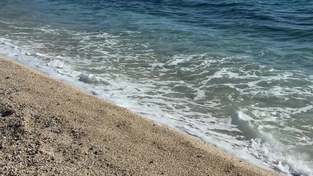 Beach shoreline on a sunny day with gentle waves and sandy textures for a scenic background