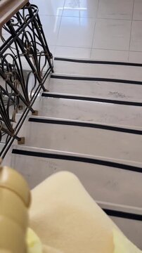 Person walking down staircase, wearing yellow outfit, seen from above for a unique perspective