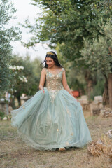 Fototapeta premium Teenage girl walking through natural landscape in formal celebration gown vertical