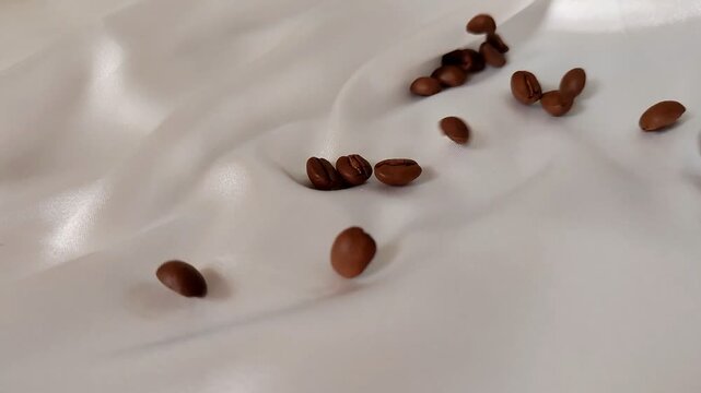 Dark Coffee Beans Flowing in Slow Motion on White Satin