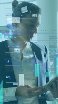 Vertical video: Businesswoman studying tablet in office then swiping, animating charts for analysis