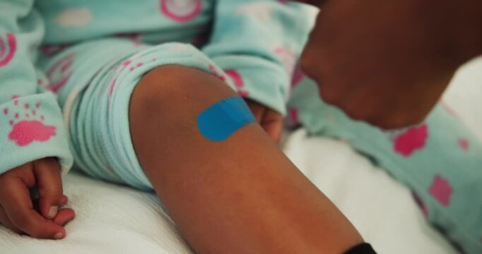 Child, injury and hands for thumbs up with bandage, bruise or first aid and help for knee in family home. Plaster, wound protection and wellness of kid with woman for healing, approval and recovery