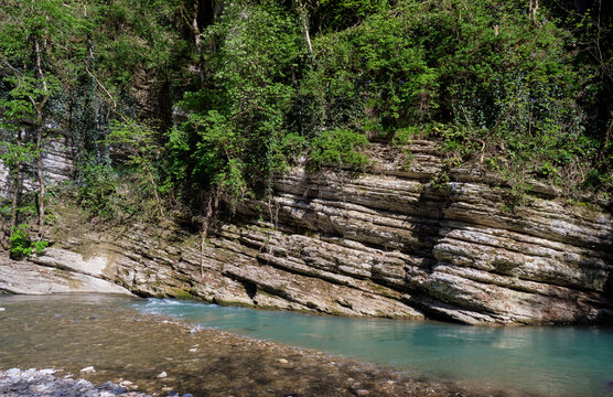 The turquoise Khosta River with white layered rocks cliffs. Yew-Boxwood Grove.