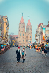 Naklejka premium Young couple standing on a historic European-style street with a church in Qingdao