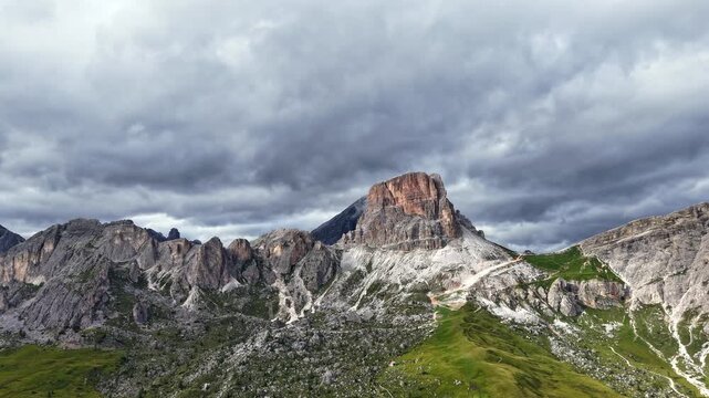 Majestic aerial Timelapse of the Ra Gusela mountain, part of the Nuvolau group in the Dolomites, under a dramatic and cloudy summer sky