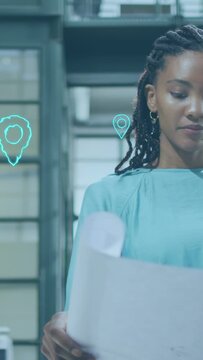 Vertical video: Designer opening plans by panes cyan pins pulsing in hovering near ear for planning