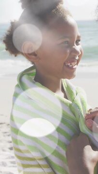 Vertical video: Mother approaching securing towel while child laughing sharing warmth for health