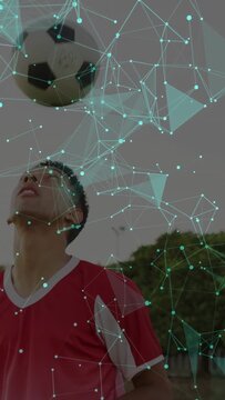 Vertical video: Sports player watching overhead soccer ball as mesh mask fading, preparing header