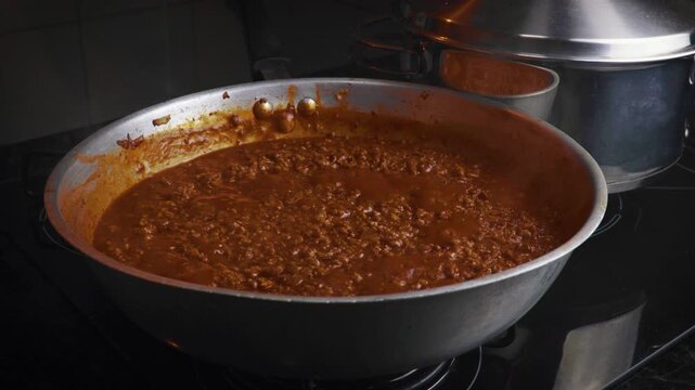 Bolognese sauce simmering in a frying pan close up
