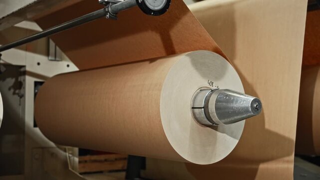 Metal Shaft Unwinding Process. Closeup Of Spool Unwinding On Metal Shaft With Tension Control