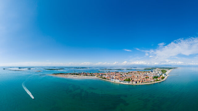 Grado, Italy with coastline, sea, and old town architecture during summer