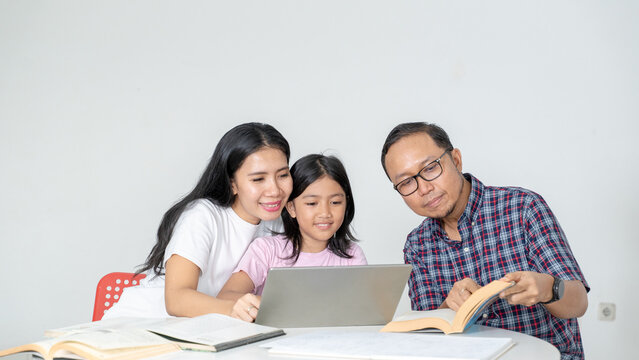 Asian Parents Helping Daughter with Online Homework on Laptop at Home