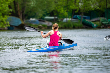 Rear view woman kayaker paddling during rowing race © Real Sports Photos