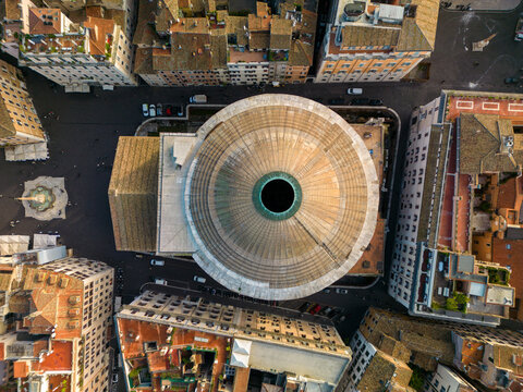 Aerial view of the Pantheon with its iconic circular dome and central oculus, surrounded by historic rooftops, narrow streets, and the city square in Rome, Lazio, Italy.